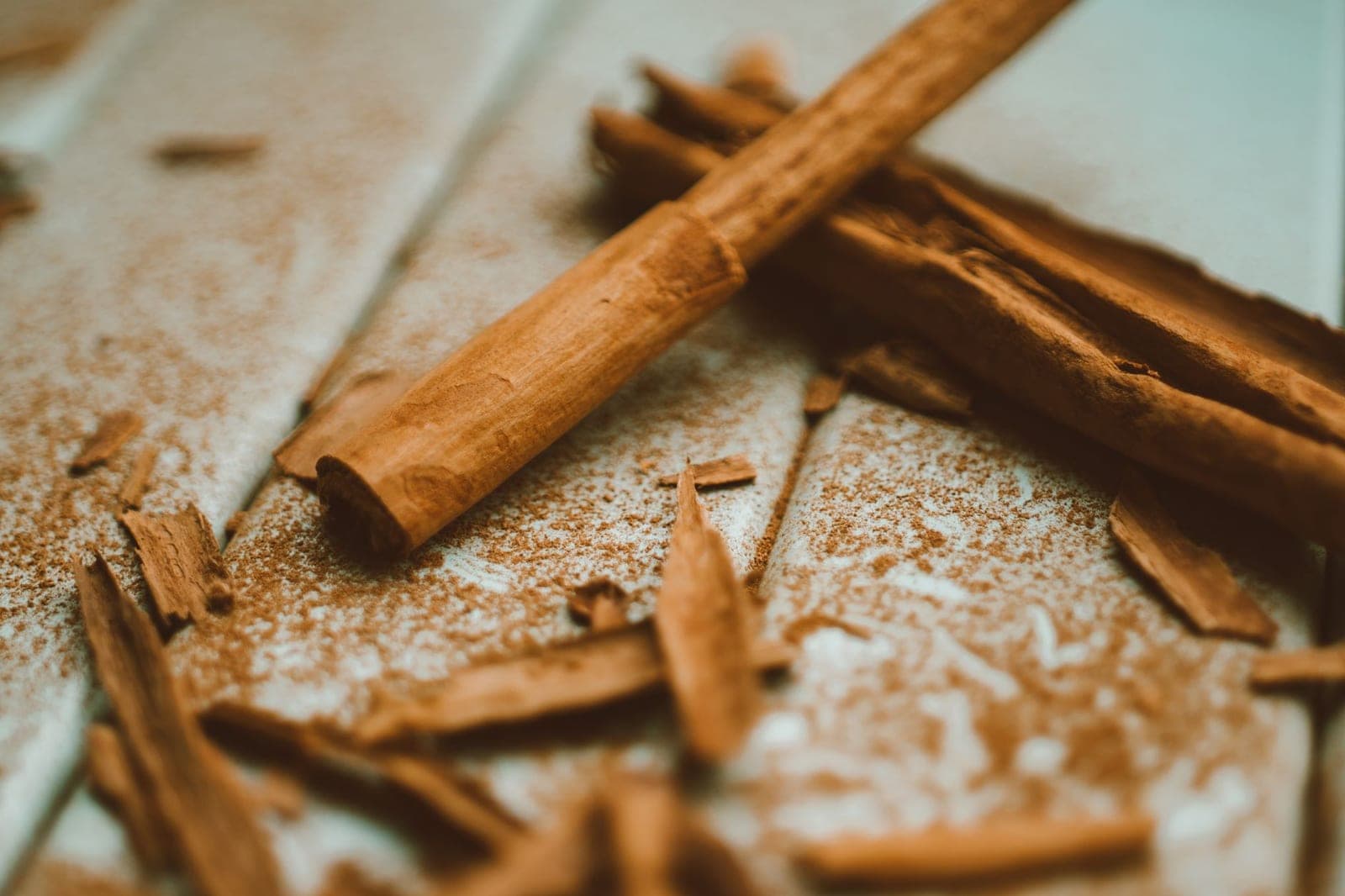 Cassia cinnamon sticks with bark shavings and a dusting of ground cinnamon